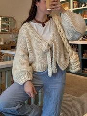 Cream chunky knit tie-front cardigan with balloon sleeves and a V-neck, styled with a white tee.