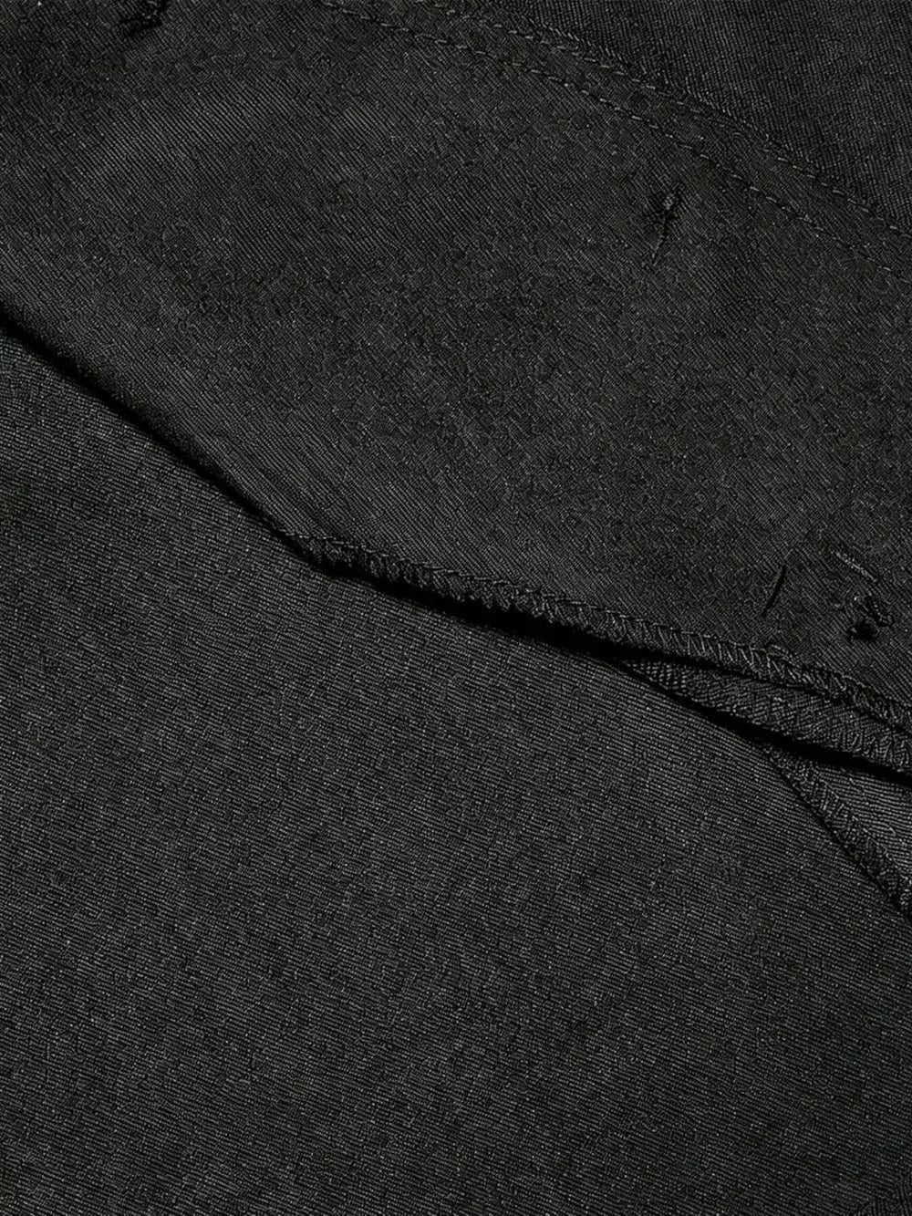 Black tailored vest with scalloped hem detail and visible stitching.