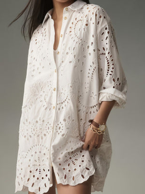 White eyelet button-up longline shirt with cutouts and ornate embroidery detail.