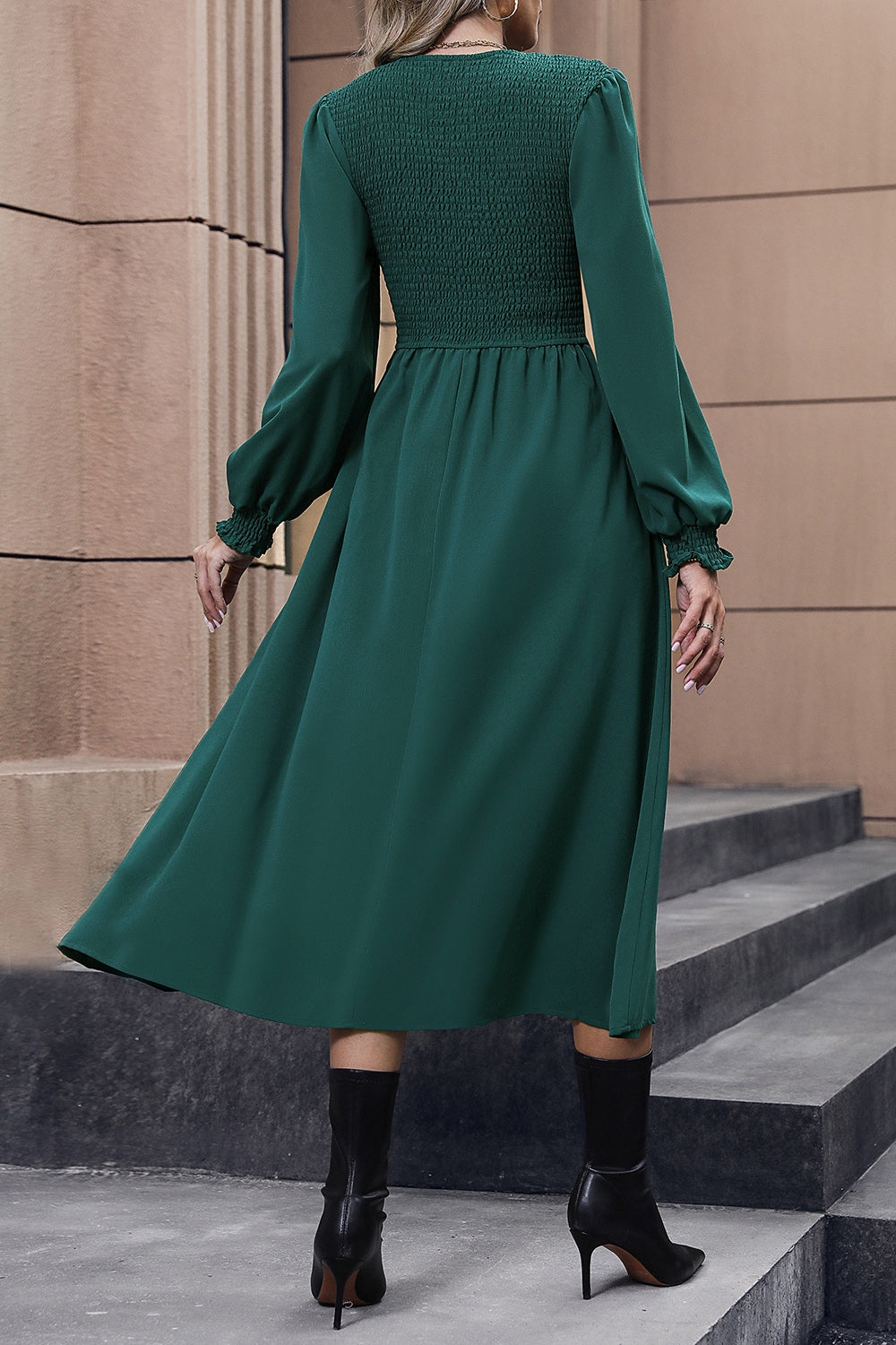Dark green midi dress with smocked bodice, long sleeves, and flared skirt.