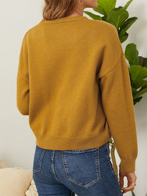 Mustard yellow knit cardigan with V-neck and button front, long sleeves.