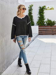 Dark gray knit pullover sweater with white trim and boat neckline.