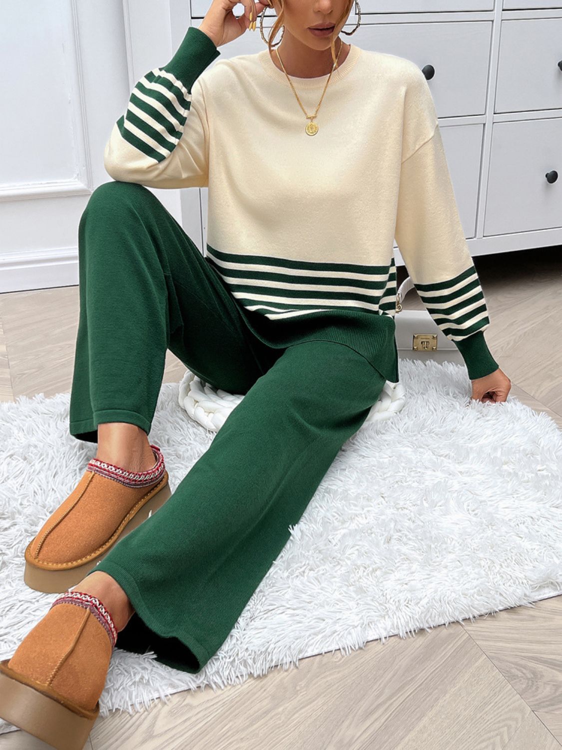 Color-blocked knit lounge set in cream and dark green with bold stripes on sleeves and hem.