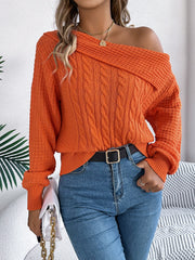 Orange off-shoulder cable knit pullover sweater with asymmetric neckline and long sleeves.