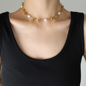 Gold linked pearl knot collar necklace with chain and pearl accents.