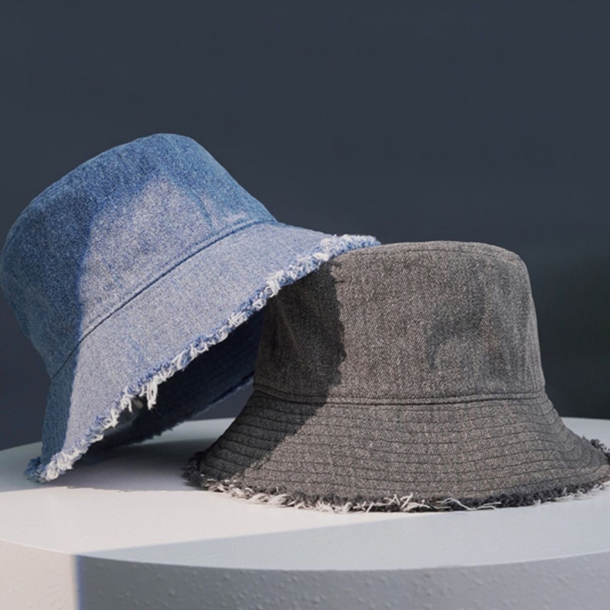 Frayed hem denim bucket hats in light blue and grey, casual accessory