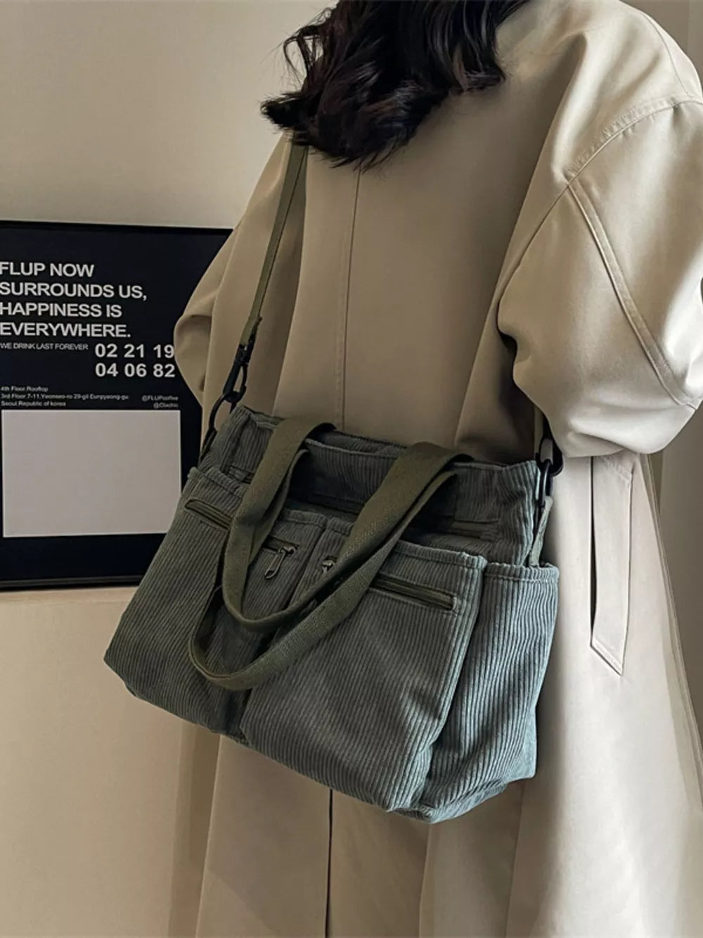 Green corduroy crossbody bag with multiple pockets and adjustable strap.