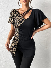 Asymmetric black top with leopard print panel, cutout neckline, and ruched detail.