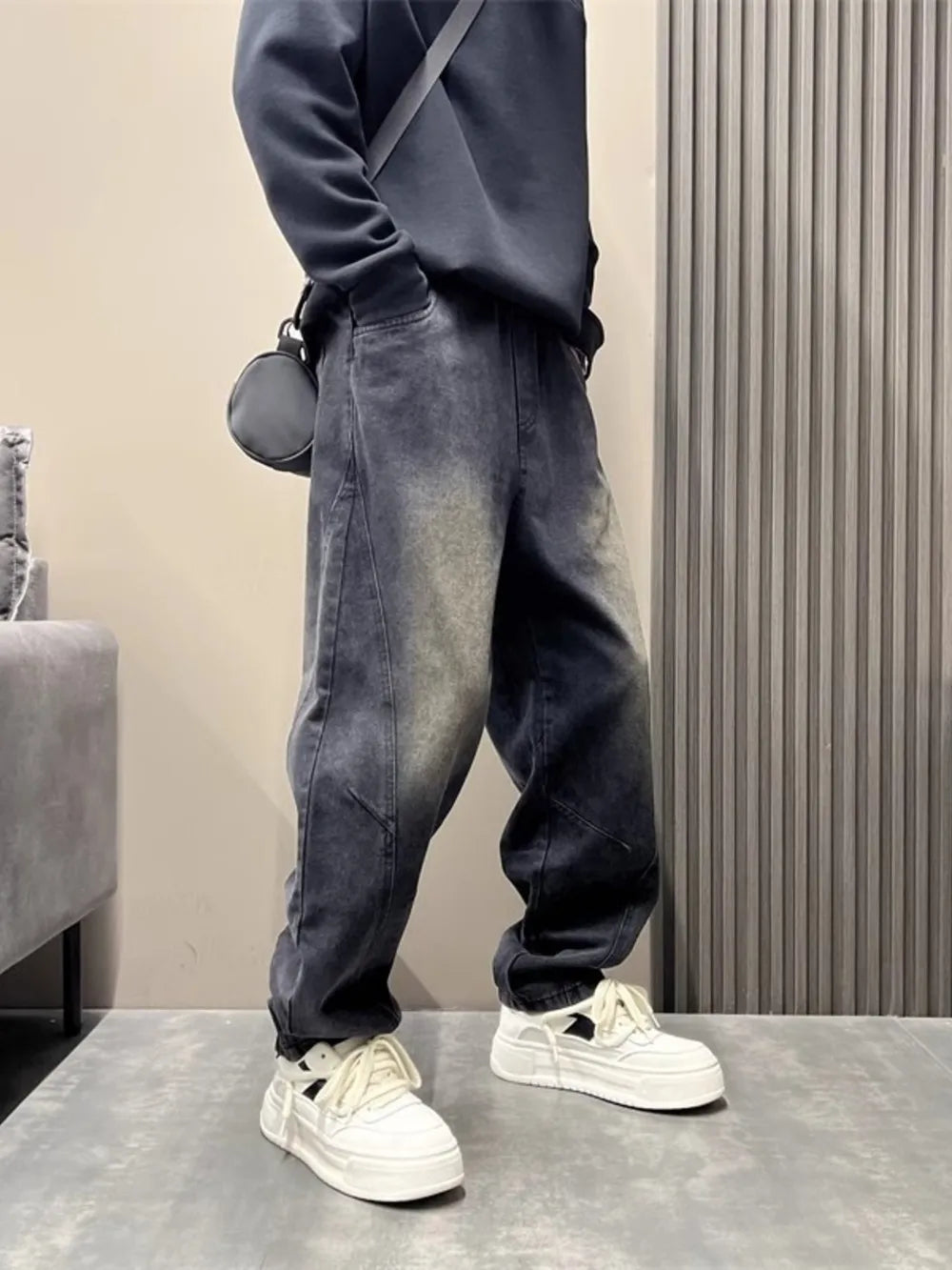 Oversized washed black men's jeans with tapered cuffs and a relaxed fit.