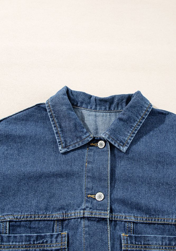 Oversized denim trucker jacket in medium blue wash with button closure and chest pockets.