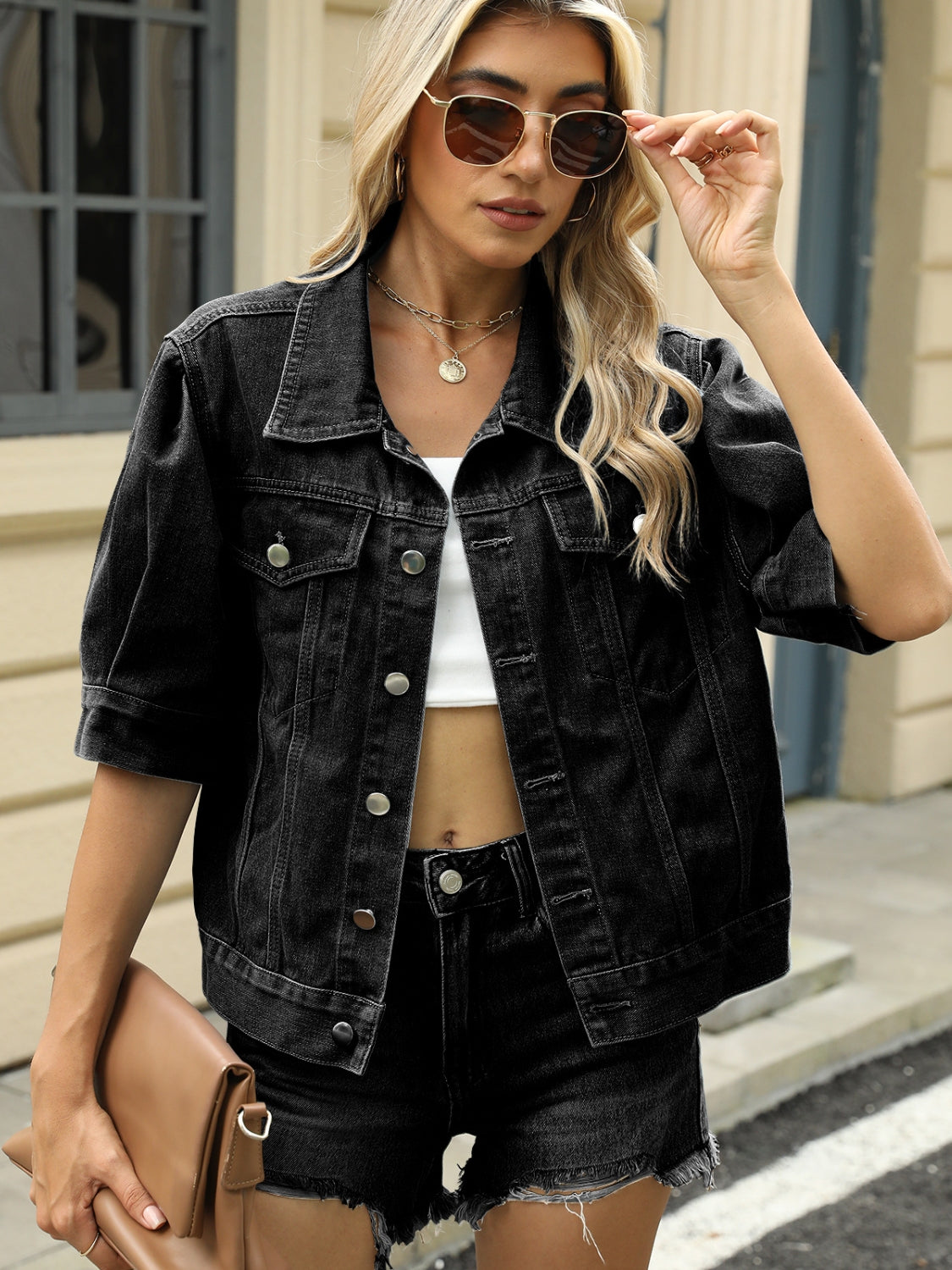 Black cropped denim jacket with puff sleeves and button front, styled with a white top.
