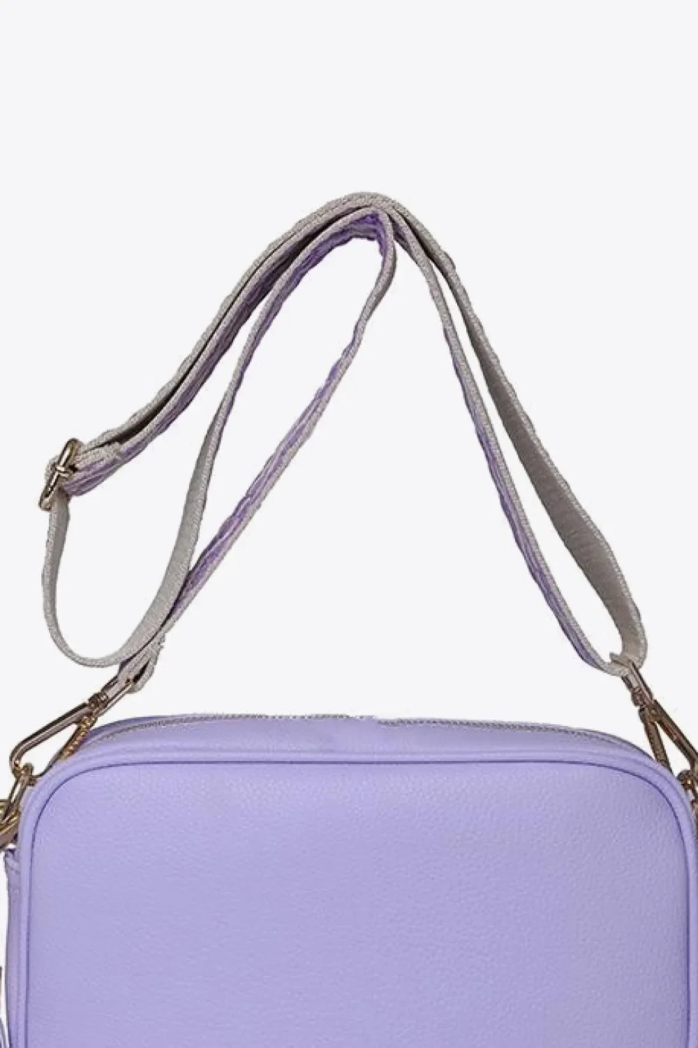 Lavender textured crossbody bag with a woven strap and gold hardware detail.