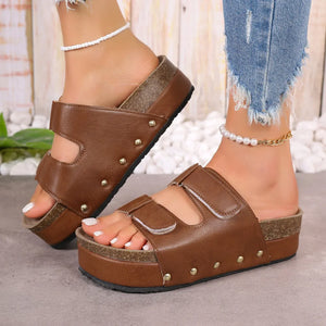Brown platform sandals with double buckle straps and stud details.