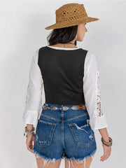 Black lace-up corset vest with white peasant sleeves and lace trim.