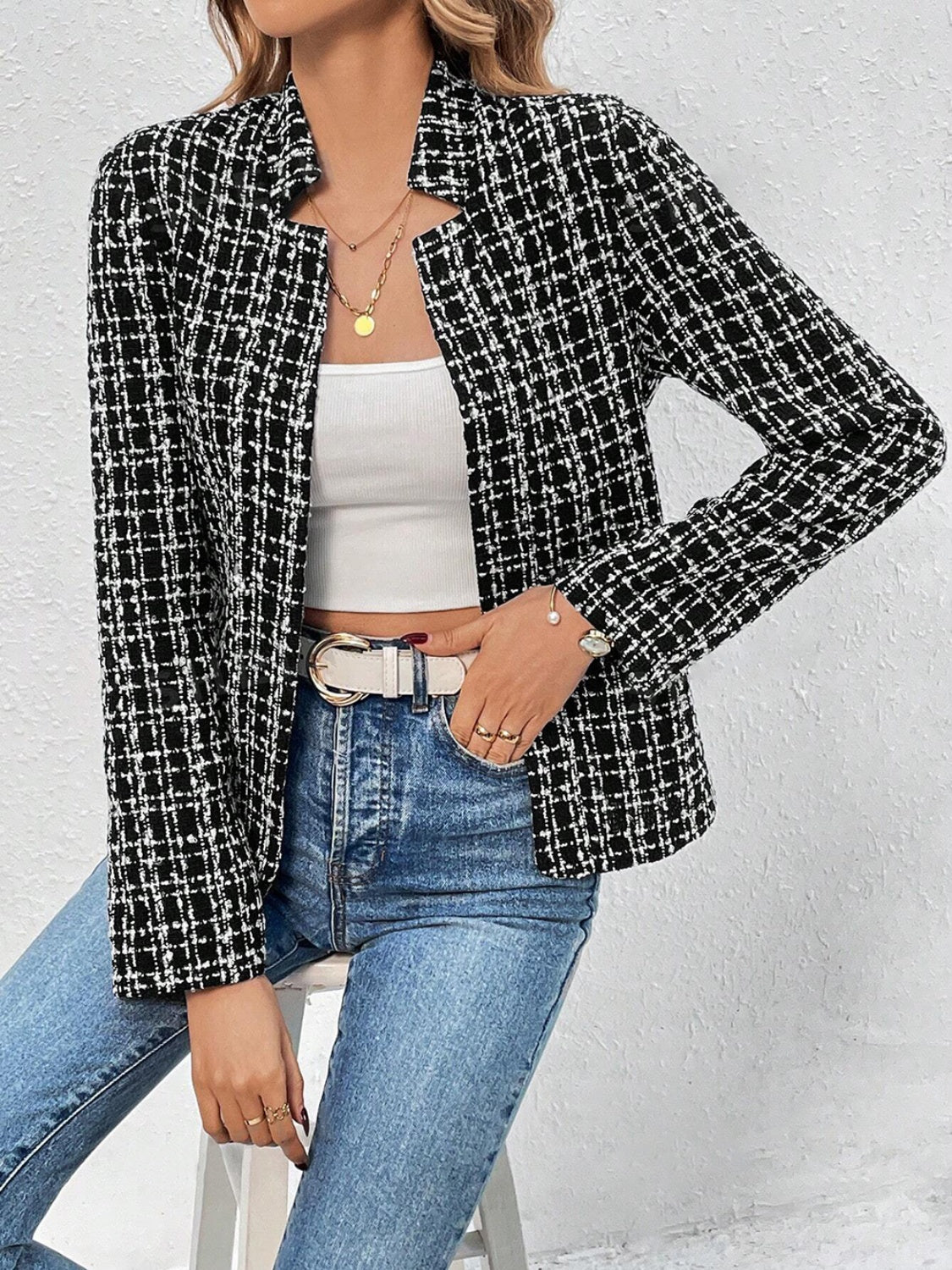 Black and white tweed open-front blazer with a plaid pattern, worn with a white top and jeans.