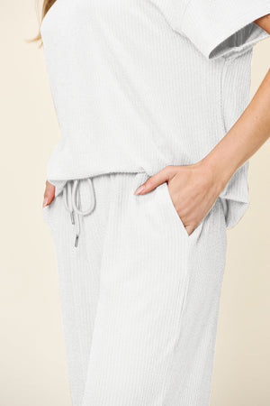 White waffle knit lounge set with drawstring waist pants and short sleeve top.