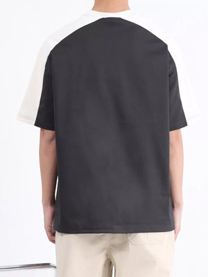 Men's contrast stitch t-shirt in black with white raglan sleeves and visible stitching detail.