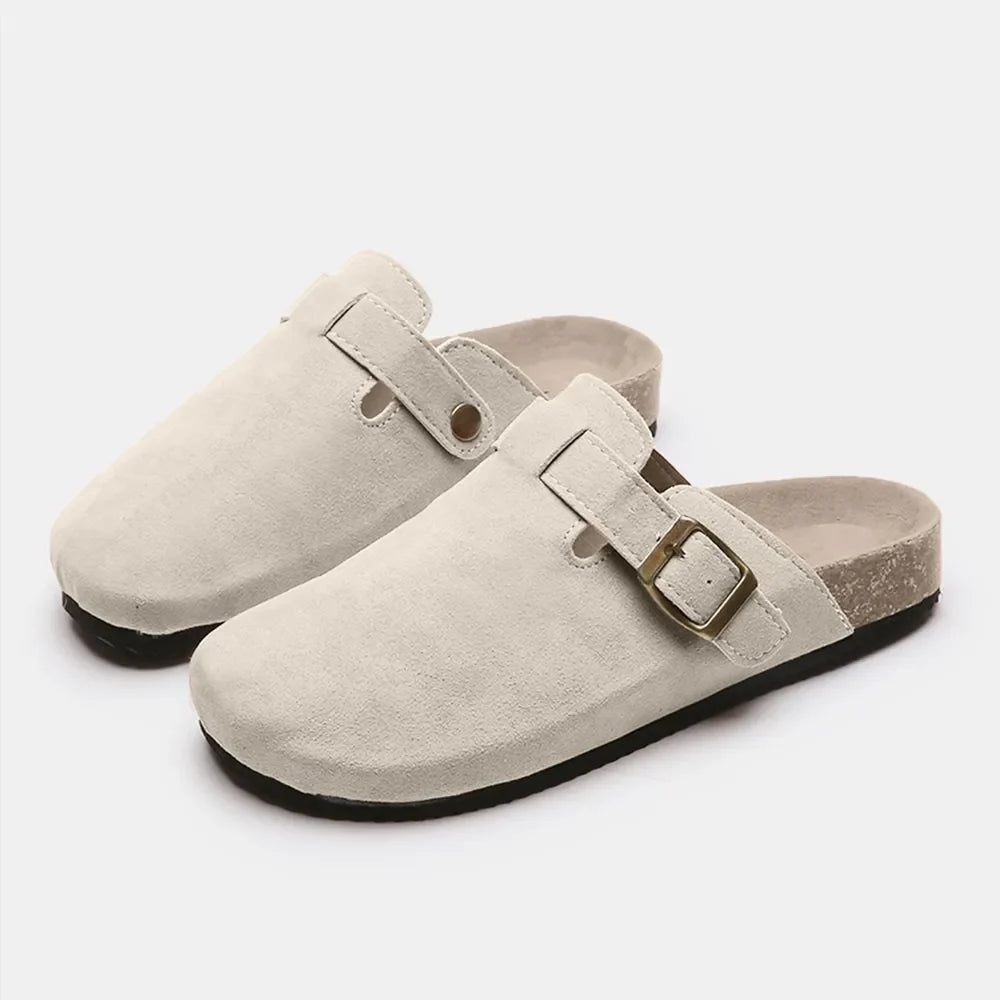 Beige suede clog slides with adjustable buckle and cork sole.