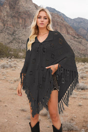 Black knit poncho with geometric pattern, fringe hem, and tie neck.