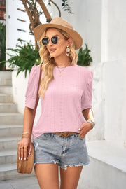 Blush pink eyelet detail puff sleeve blouse with a textured knit pattern.