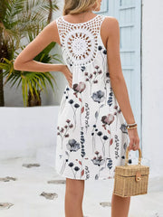 White botanical print mini dress with crochet back detail and sleeveless cut.