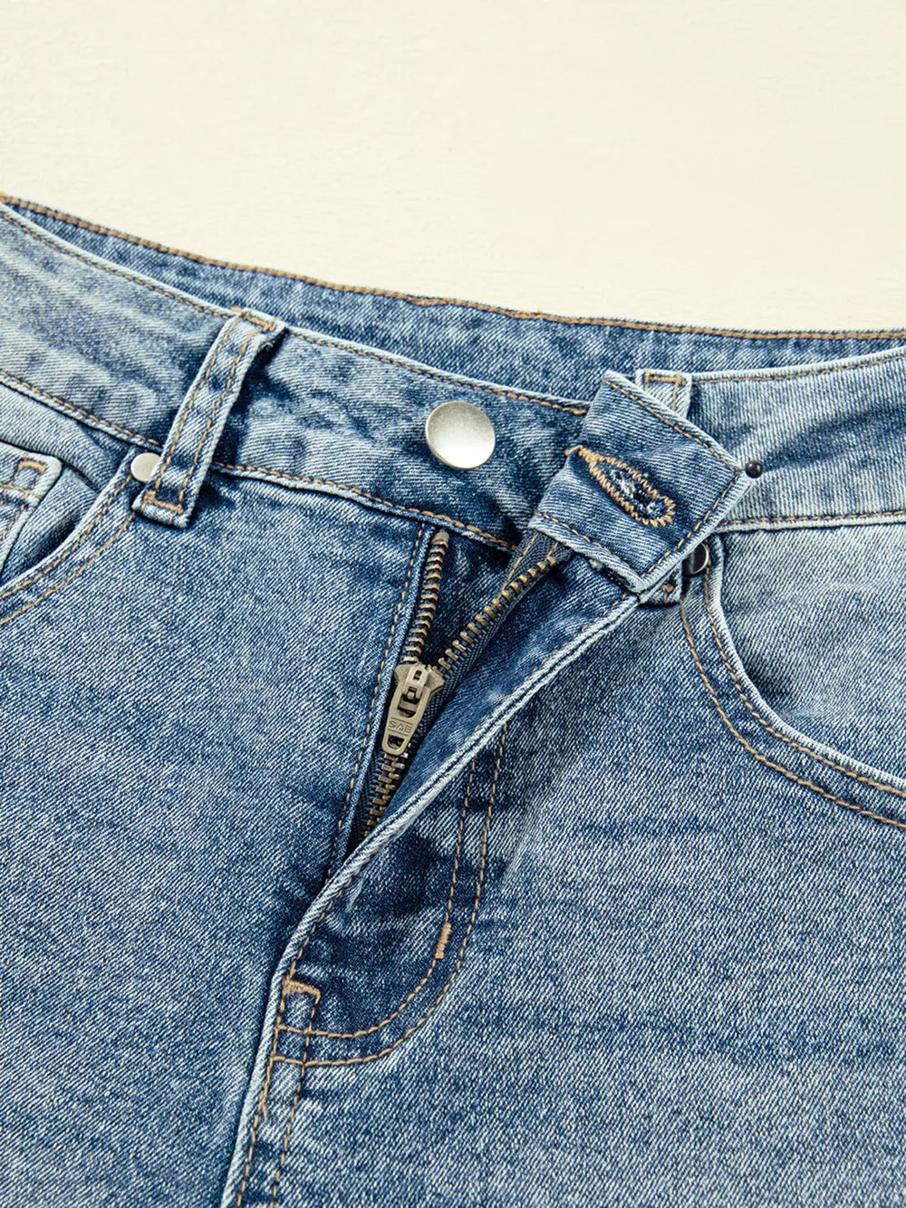 Vintage-inspired high-waisted seam jeans in blue denim with a zip fly and button closure.