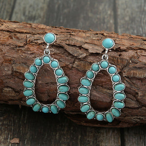 Teal teardrop statement earrings with artificial turquoise stones and alloy setting.