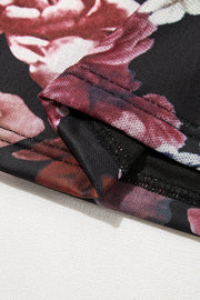Black mesh blouse with a romantic floral print and visible seams.