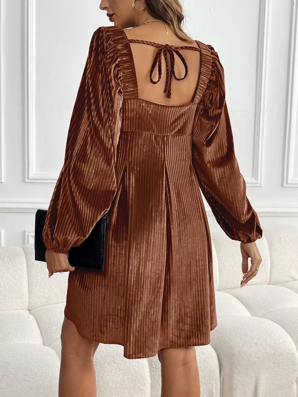 Brown velvet mini dress with square neckline, puff sleeves, and back tie detail.