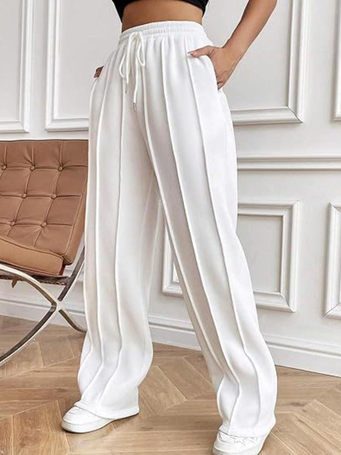 White pleated wide-leg lounge trousers with drawstring waist and side pockets.
