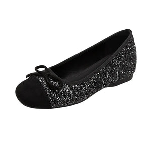 Black glitter ballet flats with a suede cap toe and bow detail.