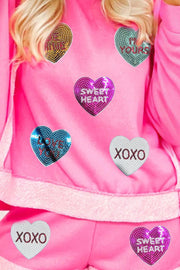 Pink loungewear set with sequin heart appliques that say Sweetheart, Love You, I'm Yours, and XOXO.