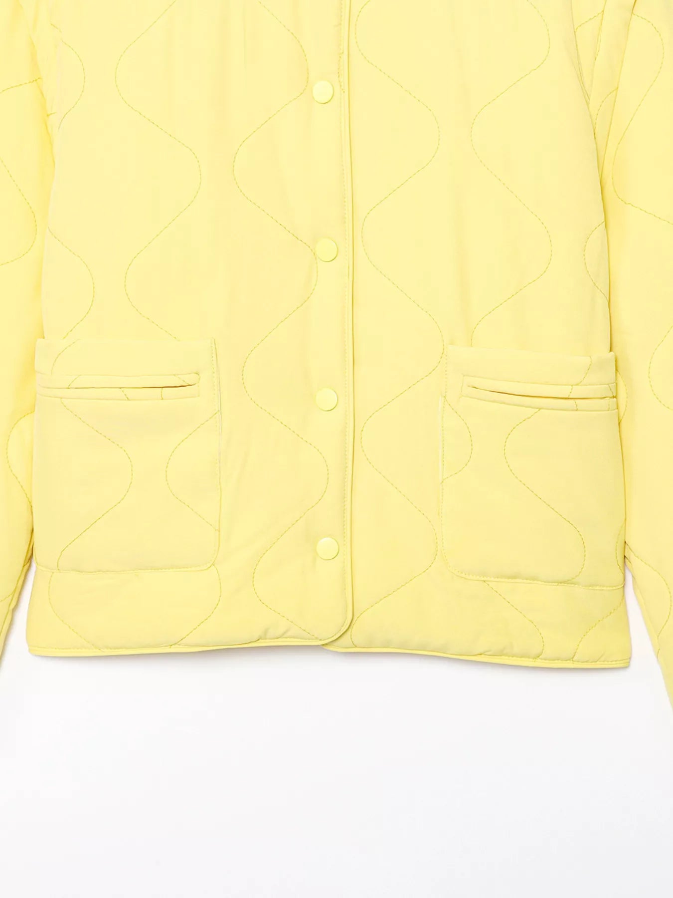 Yellow quilted snap puffer jacket with wave stitching and patch pockets.