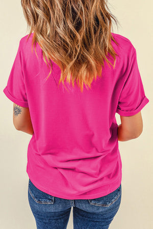 Hot pink t-shirt with rolled sleeves and a graphic daisy print on the front.