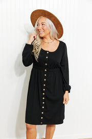 Black button-down empire waist mini dress with long sleeves and a square neckline.