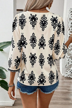 Ivory V-neck blouse with black embroidered pattern and contrast trim sleeves