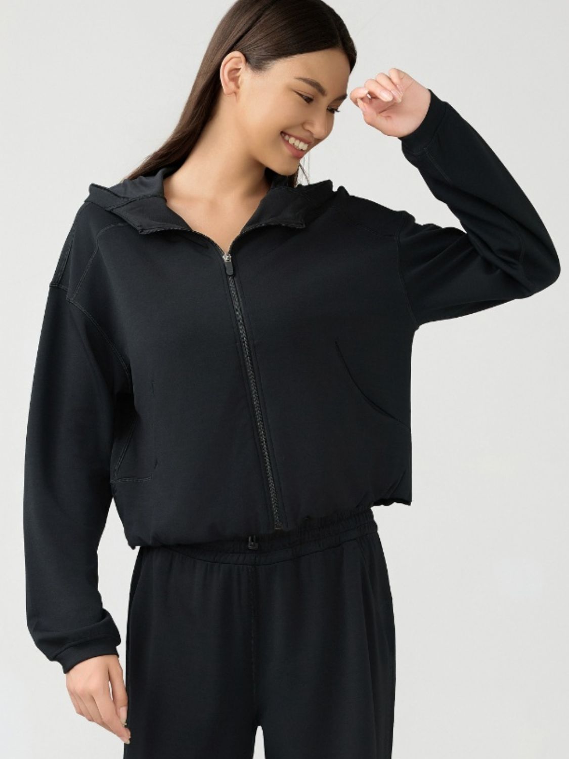 Black cropped active hoodie with zipper, hood, and pockets.