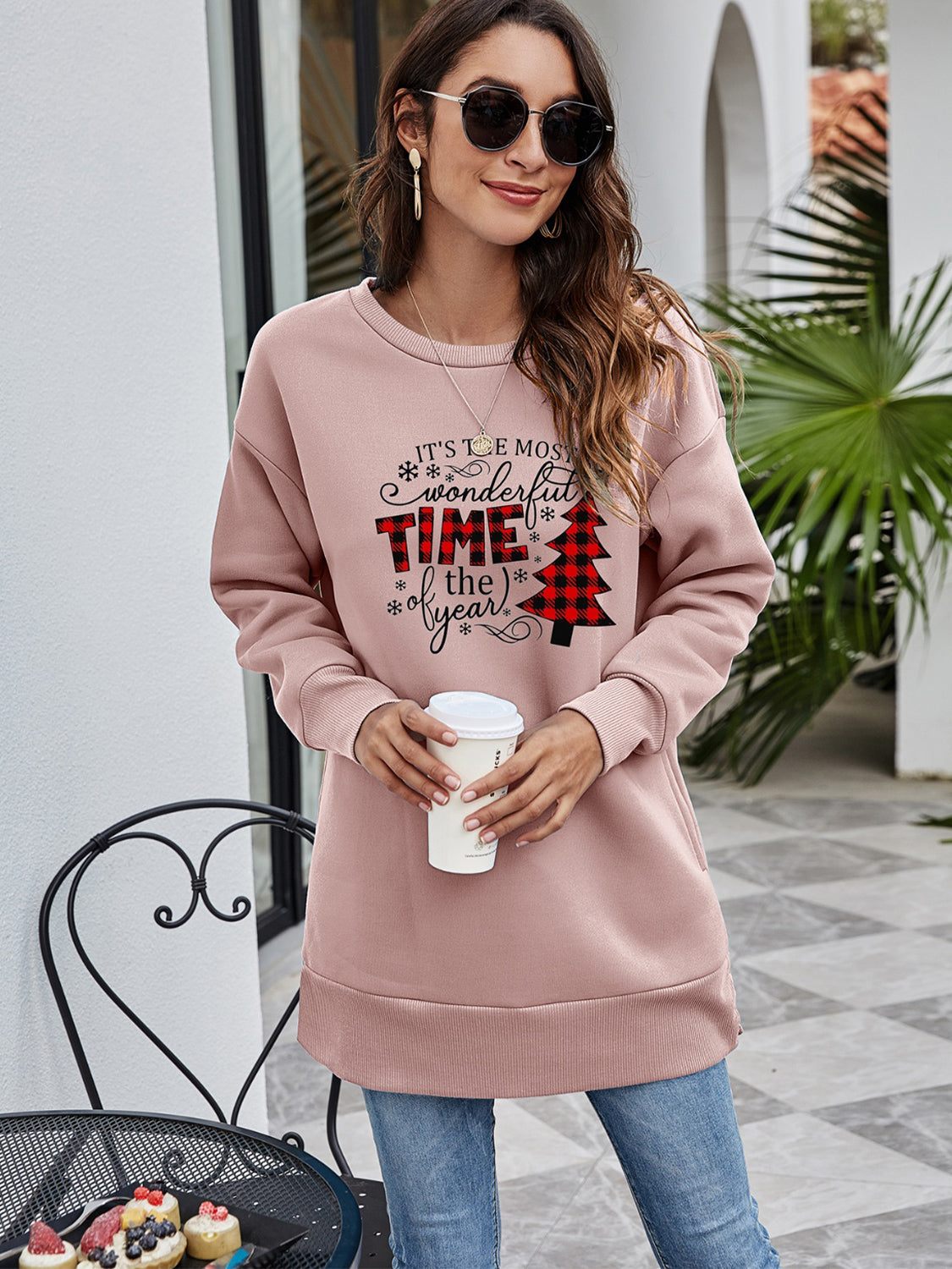 Dusty Pink tunic sweatshirt with holiday graphic and crew neck, styled with jeans.