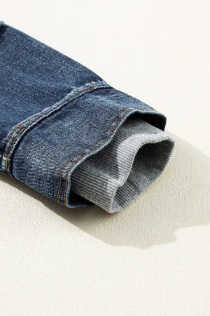 Dark blue denim jacket sleeve with grey knit hood layer detail.