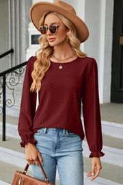 Burgundy textured puff sleeve blouse with ruffled cuffs and crew neck.