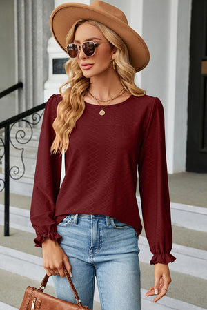 Burgundy textured puff sleeve blouse with ruffled cuffs and crew neck.