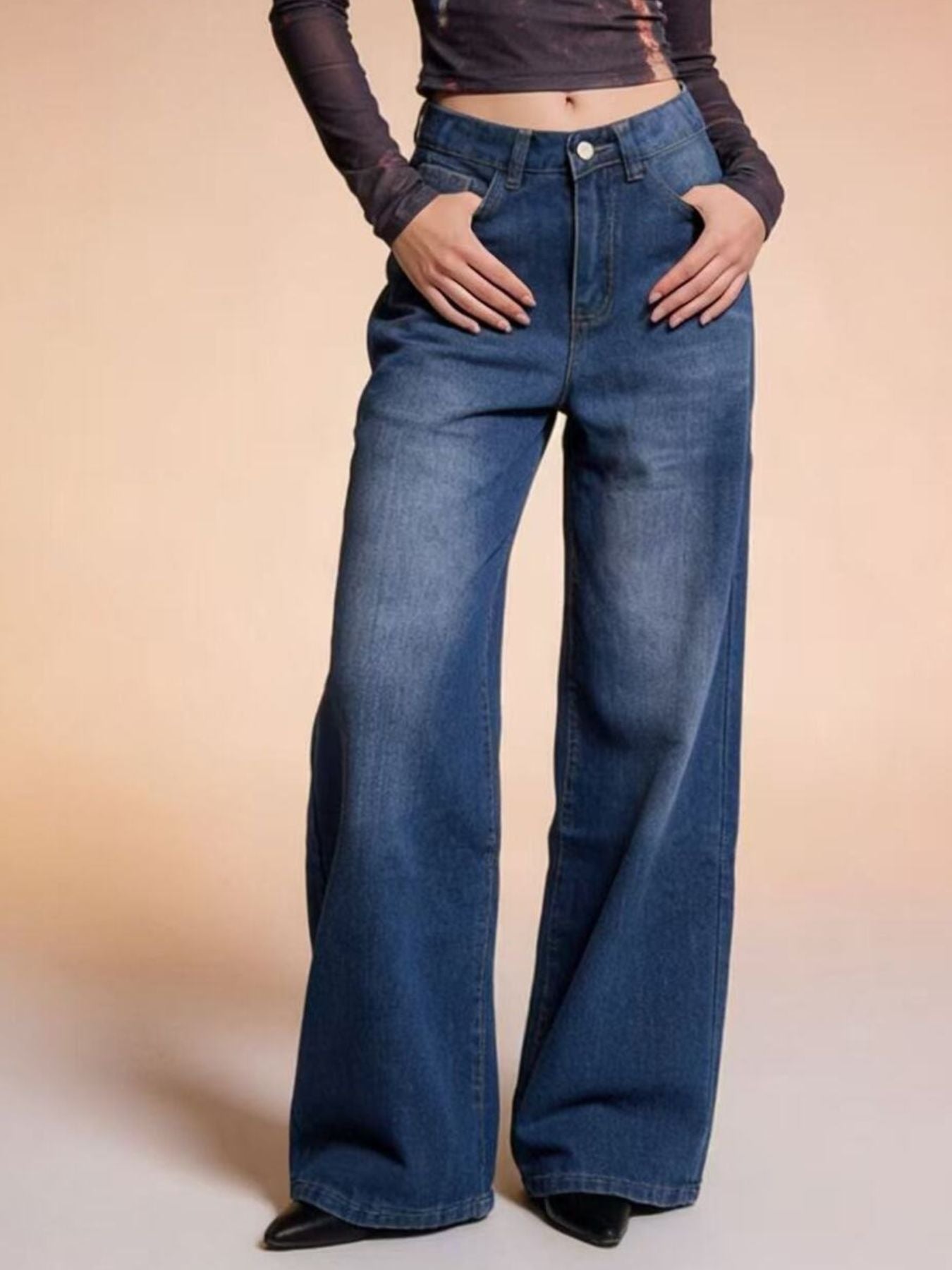Cutout high-waisted wide-leg jeans in blue denim with button closure and pockets.