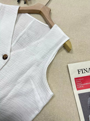 White textured vest with tortoiseshell button detail