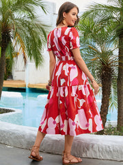 Red floral print midi dress with smocked waist and tiered skirt.
