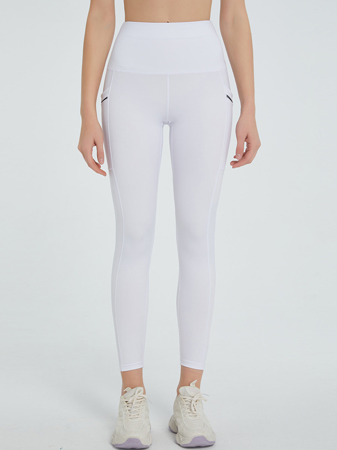 White pocketed leggings with a high waist and seam details.