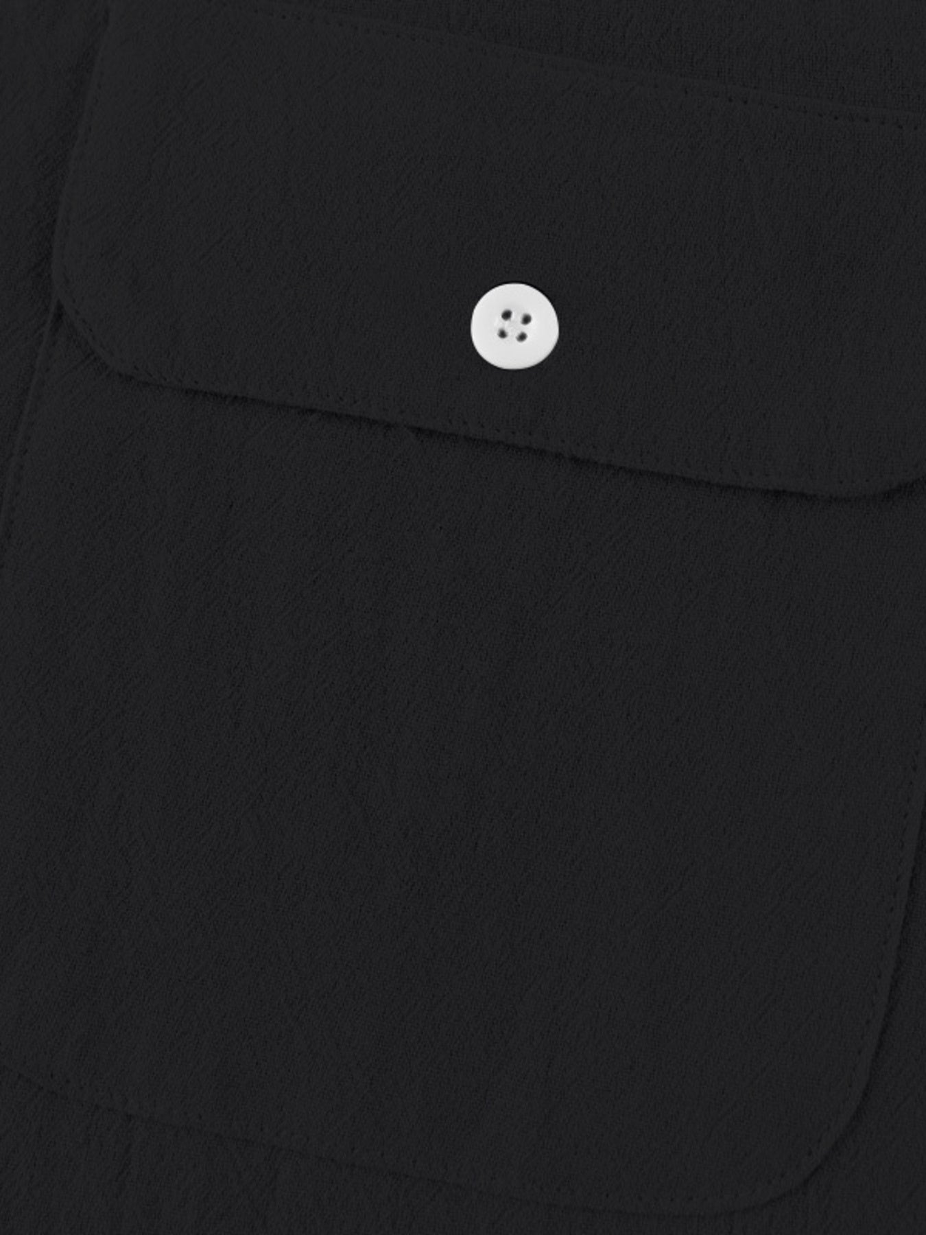 Black short sleeve henley shirt with textured fabric and a white button pocket detail.