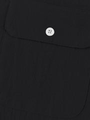Black short sleeve henley shirt with textured fabric and a white button pocket detail.