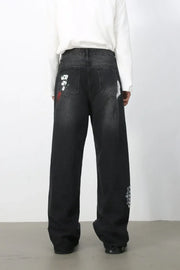 Dark wide-leg jeans with painterly brushstroke details and distressed accents.