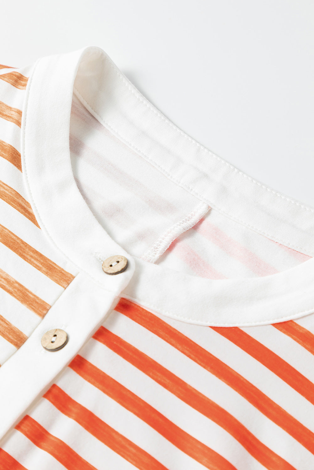 Colorblock stripe sleeveless jumpsuit with white collar and wooden buttons.