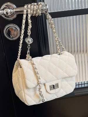 Quilted chain crossbody clutch in Rice White with silver hardware and a decorative ball charm.